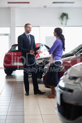 Salesman and a woman talking next to a car