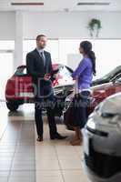 Salesman and a woman talking next to a car