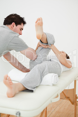 Brown-haired woman lying while stretching her leg