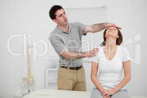 Serious practitioner placing his hand on the forehead of a woman