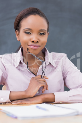 Teacher smiling while holding glasses