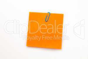 Orange adhesive note with a paperclip