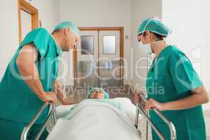 Surgeons leaning on a medical bed