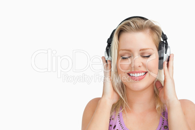 Happy blonde woman listening to music with headphones