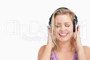 Happy blonde woman listening to music with headphones