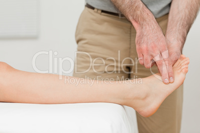 Fingers of a physiotherapist touching a foot