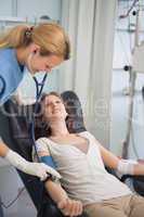 Nurse auscultating a patient