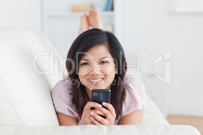 Smiling woman on a couch with a phone in her hands