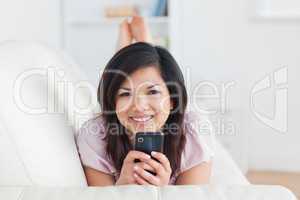 Smiling woman on a couch with a phone in her hands