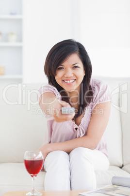 Woman smiling and holding a television remote