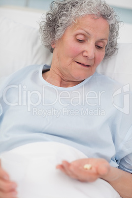 Patient looking at drugs in her hand