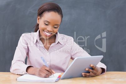 Teacher smiling while holding a tablet computer