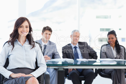 Young businesswoman sitting with her hand on her leg and accompa