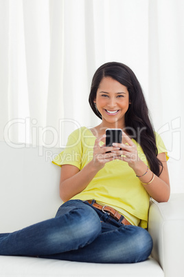 Portrait of a happy Latino looking her smartphone