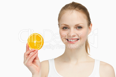 Cheerful woman presenting an orange slice
