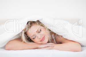 Young woman resting under her duvet