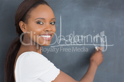 Teacher showing the blackboard while smiling