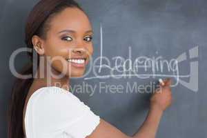 Teacher showing the blackboard while smiling