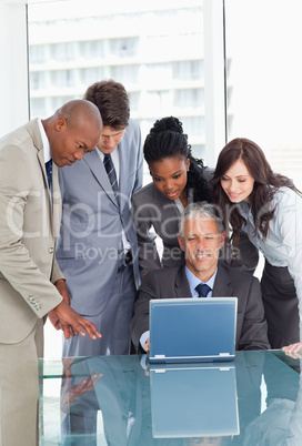 Business team earnestly listening to their mature and smiling ma