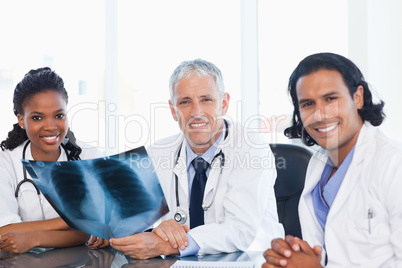 Medical team smiling while working on a patient's x-ray