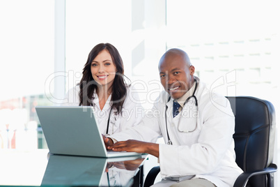 Two nurses working seriously while sitting at the desk in a well