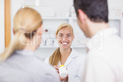 Blonde pharmacist holding a drug box