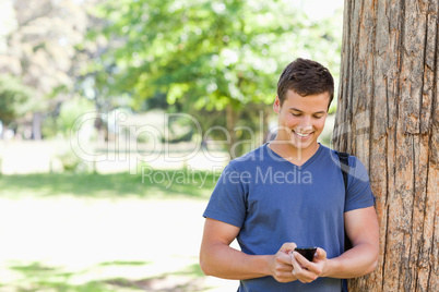 Muscled student using a smartphone