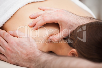 Osteopath massaging his patient while pressing his tumb