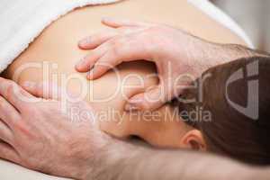 Osteopath massaging his patient while pressing his tumb