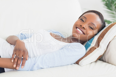 Black woman lying on back on a sofa