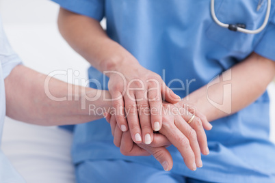 Close up of a nurse touching hand of a patient