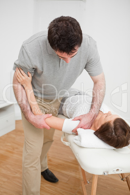 Osteopath working on a shoulder of a patient