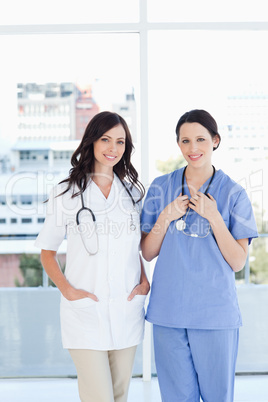 Two young medical interns wearing their hospital uniform