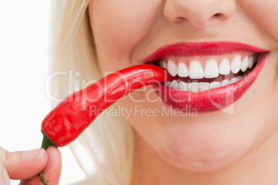 Happy woman eating a red chili