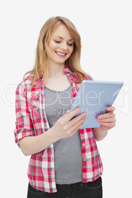 Woman holding a tablet computer while standing