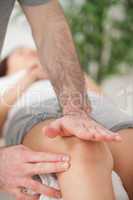 Physiotherapist using his hand palm to massage a knee
