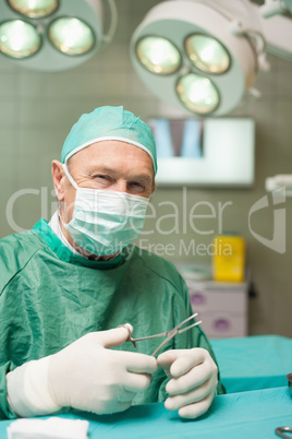 Smiling doctor holding scissors