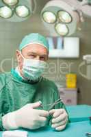 Smiling doctor holding scissors