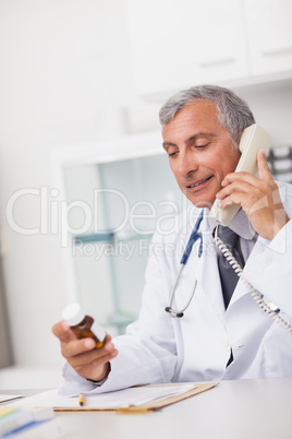 Doctor holding a drug box and a phone