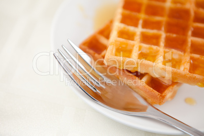 Two waffles and a fork on a saucer