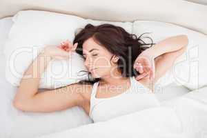 Peaceful woman stretching her body while getting up