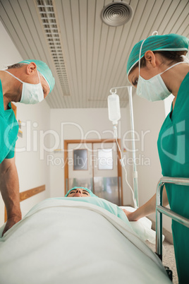 Surgeons looking at a patient asleep