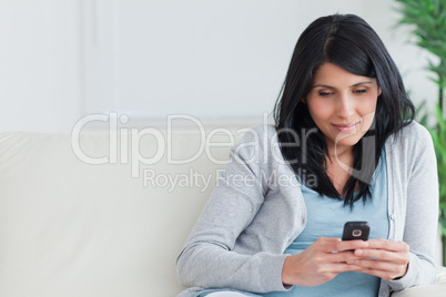 Woman holding a telephone while relaxing on a couch