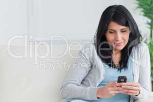 Woman holding a telephone while relaxing on a couch