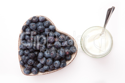 White yogurt and blueberries in a heart shaped bowl