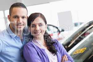 Couple hugging in front of a car