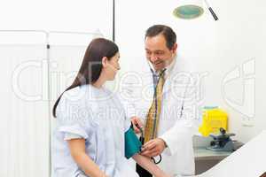 Smiling doctor placing a sphygmomanometer