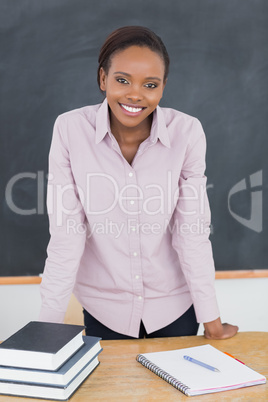 Teacher standing up while leaning on desk