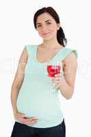 Pregnant woman holding a mocktail