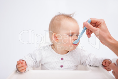 Cute baby eating while being accompanied by her mother